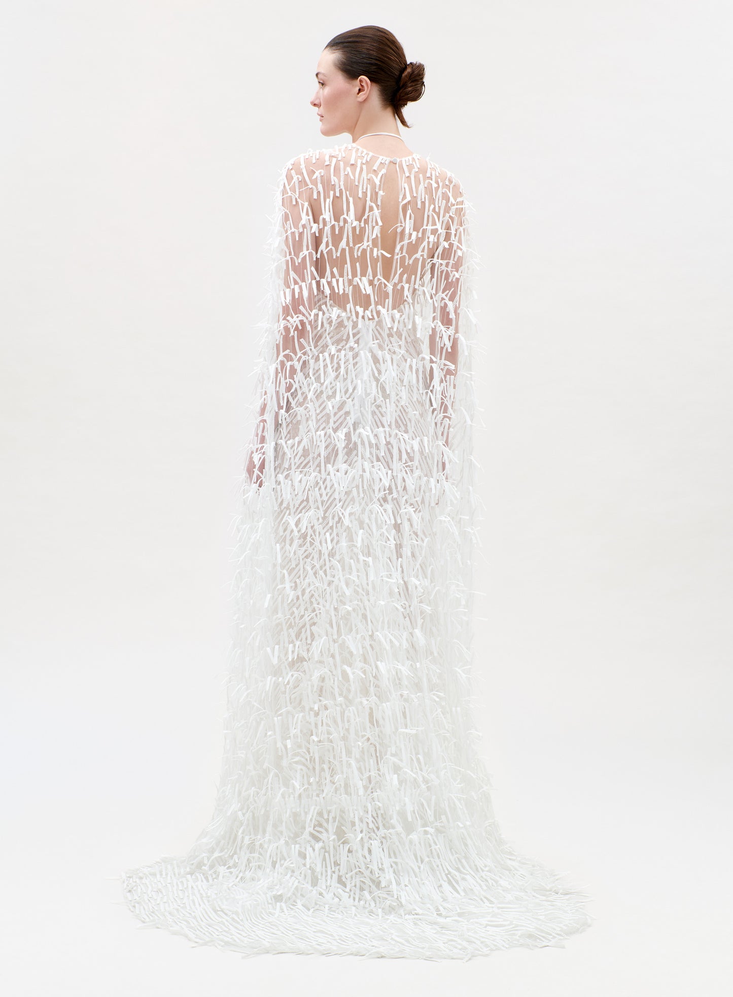 Woman wearing a white lace dress on a plain background