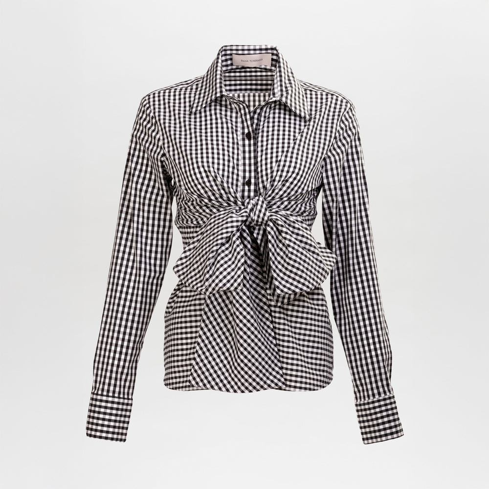 The Mercury Blouse is a black and white gingham long-sleeve shirt featuring a pointed collar and a front waist tie, shown on a plain background.