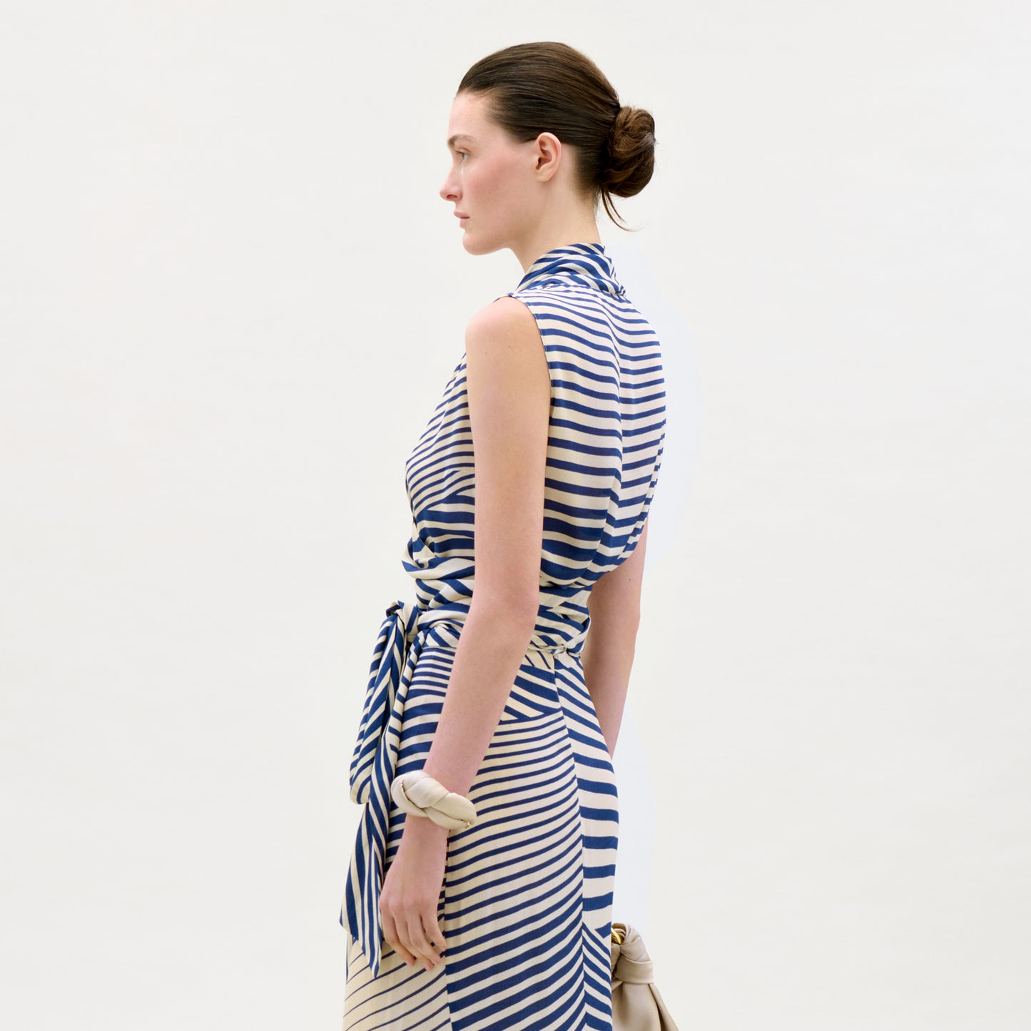 Woman wearing a blue and white striped dress against a plain background