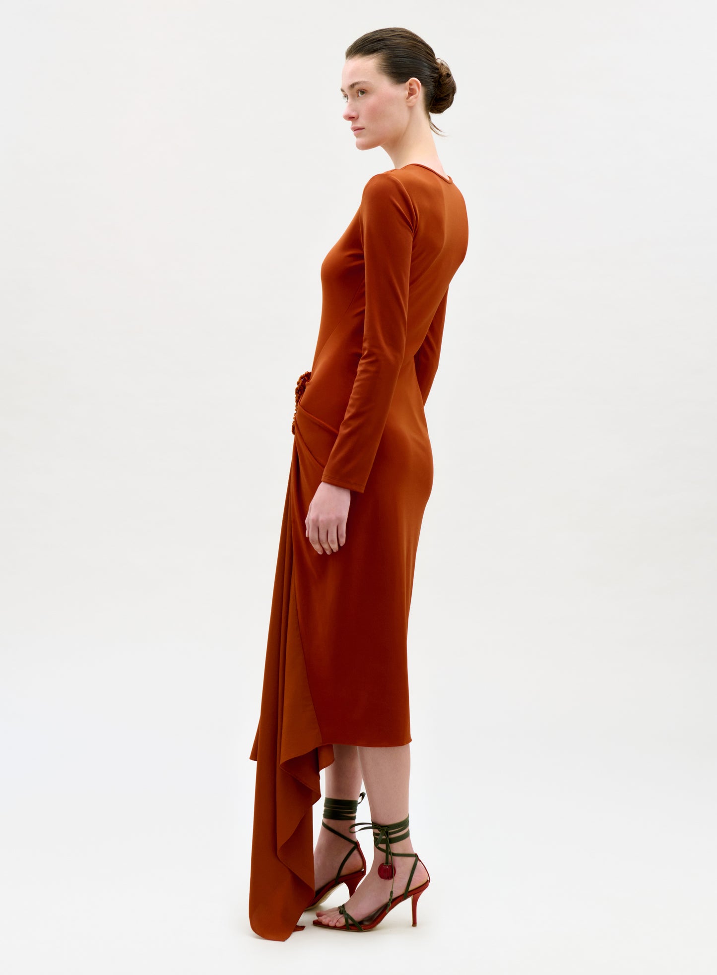 Woman wearing a rust-colored dress on a white background