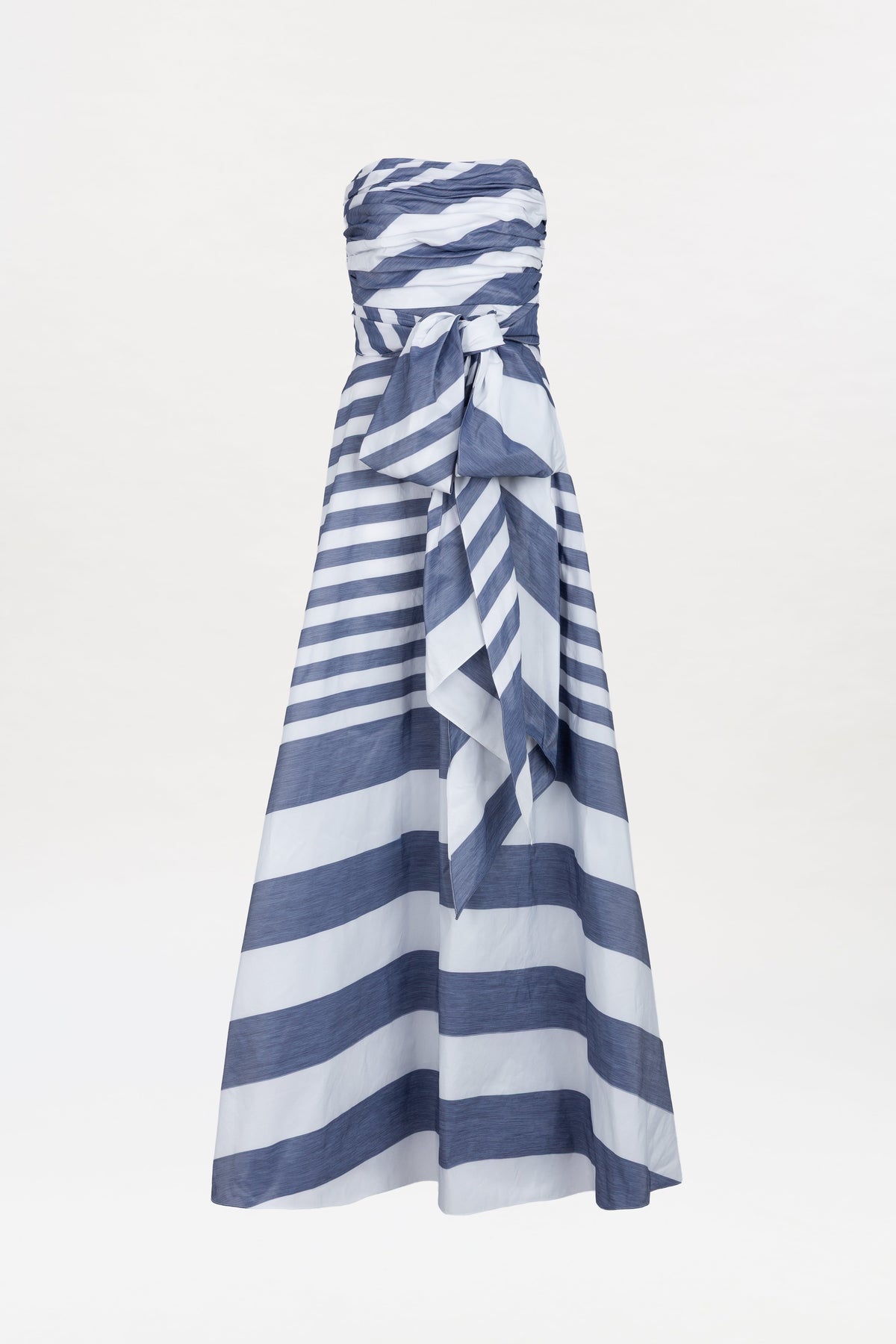 The Leyna Dress is a strapless, floor-length gown featuring wide horizontal navy and white stripes and a statement bow at the waist, shown against a plain white background.