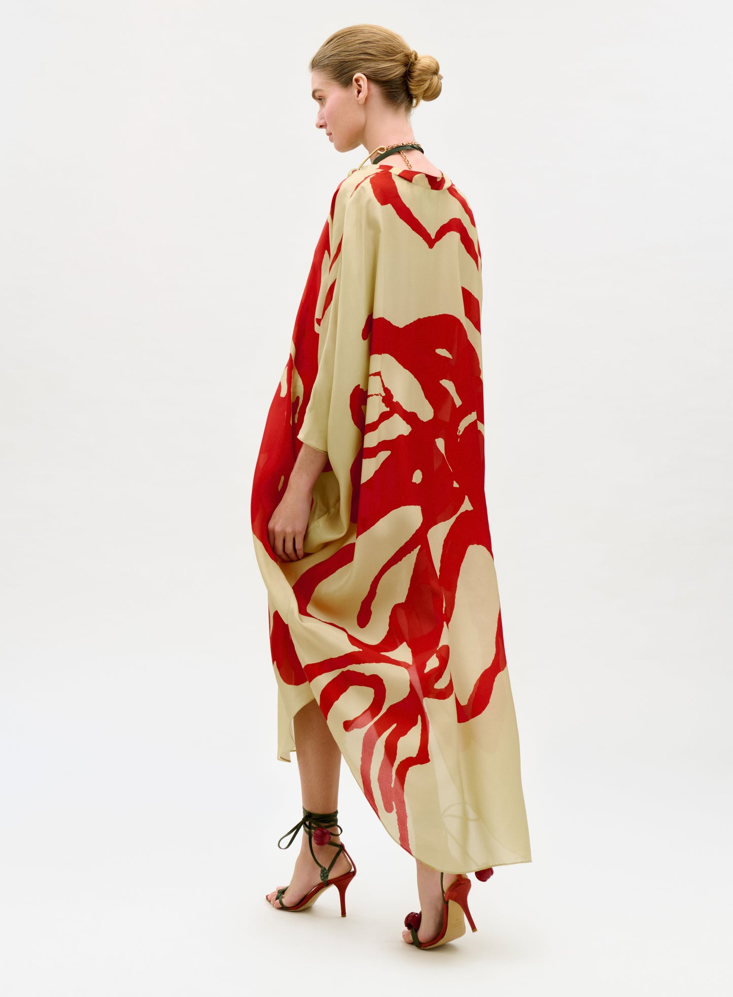 Woman wearing a red and beige floral dress on a white background