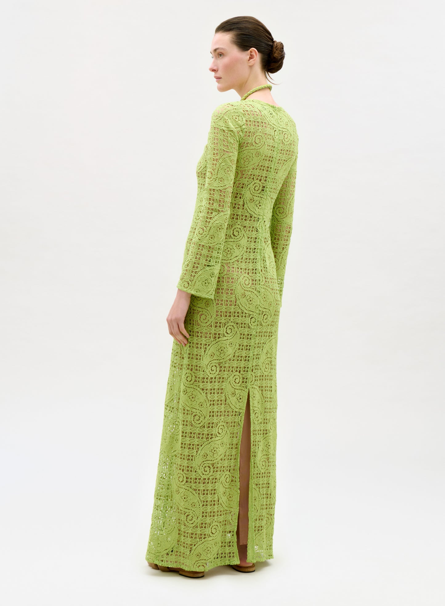 Woman wearing a green lace dress on a white background