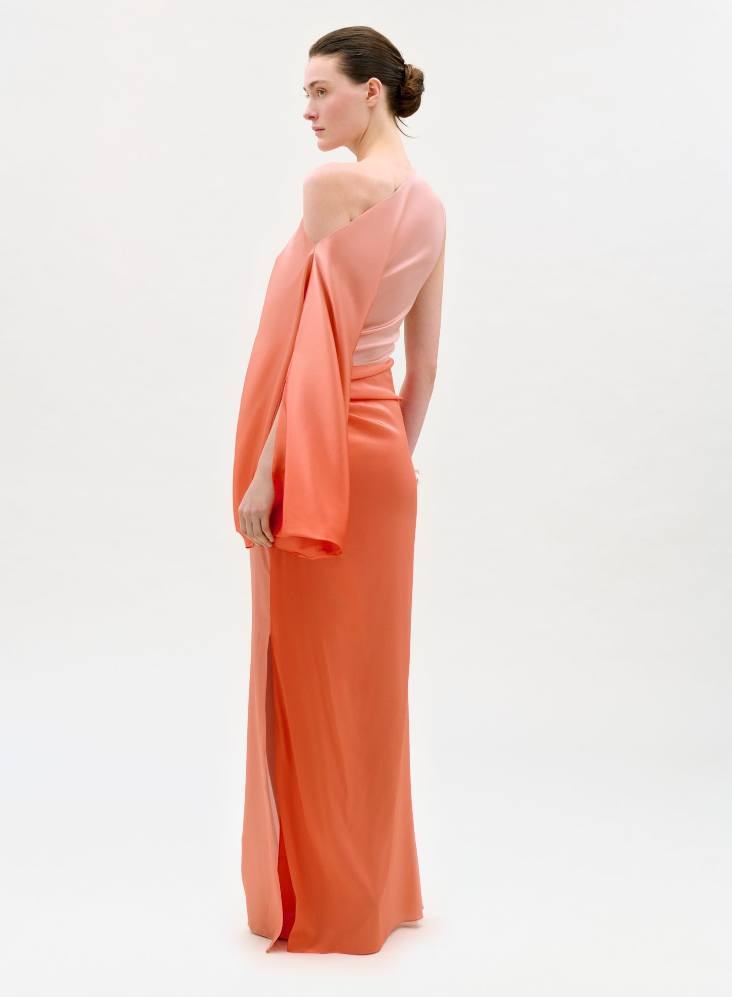 Woman wearing a peach evening gown with a white background