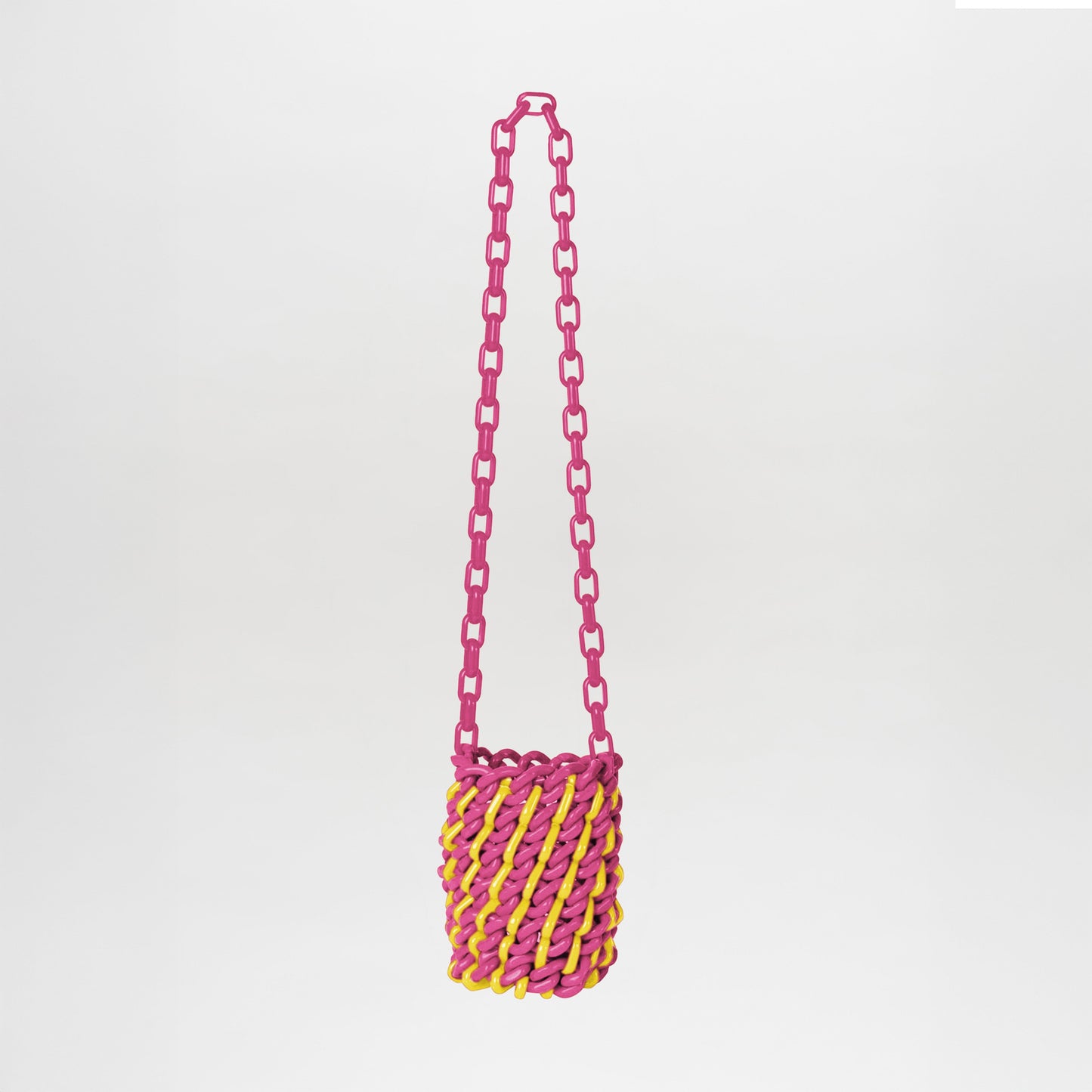 The Anise Bag Fuchsia Yellow features a pink chain strap and a body of twisted fuchsia and yellow material, displayed on a plain white background.