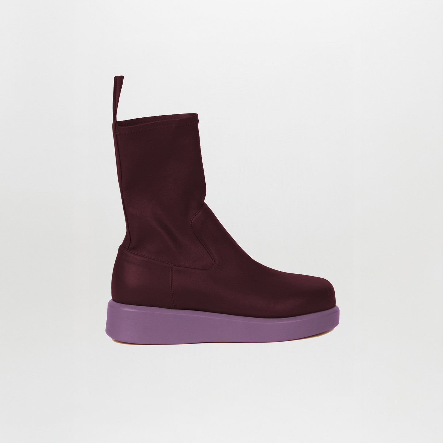 The Baia Boots Lillac by Silvia Tcherassi are maroon mid-calf boots in soft stretch calf leather, featuring a back loop and thick flat lavender sole, photographed against a plain white background.