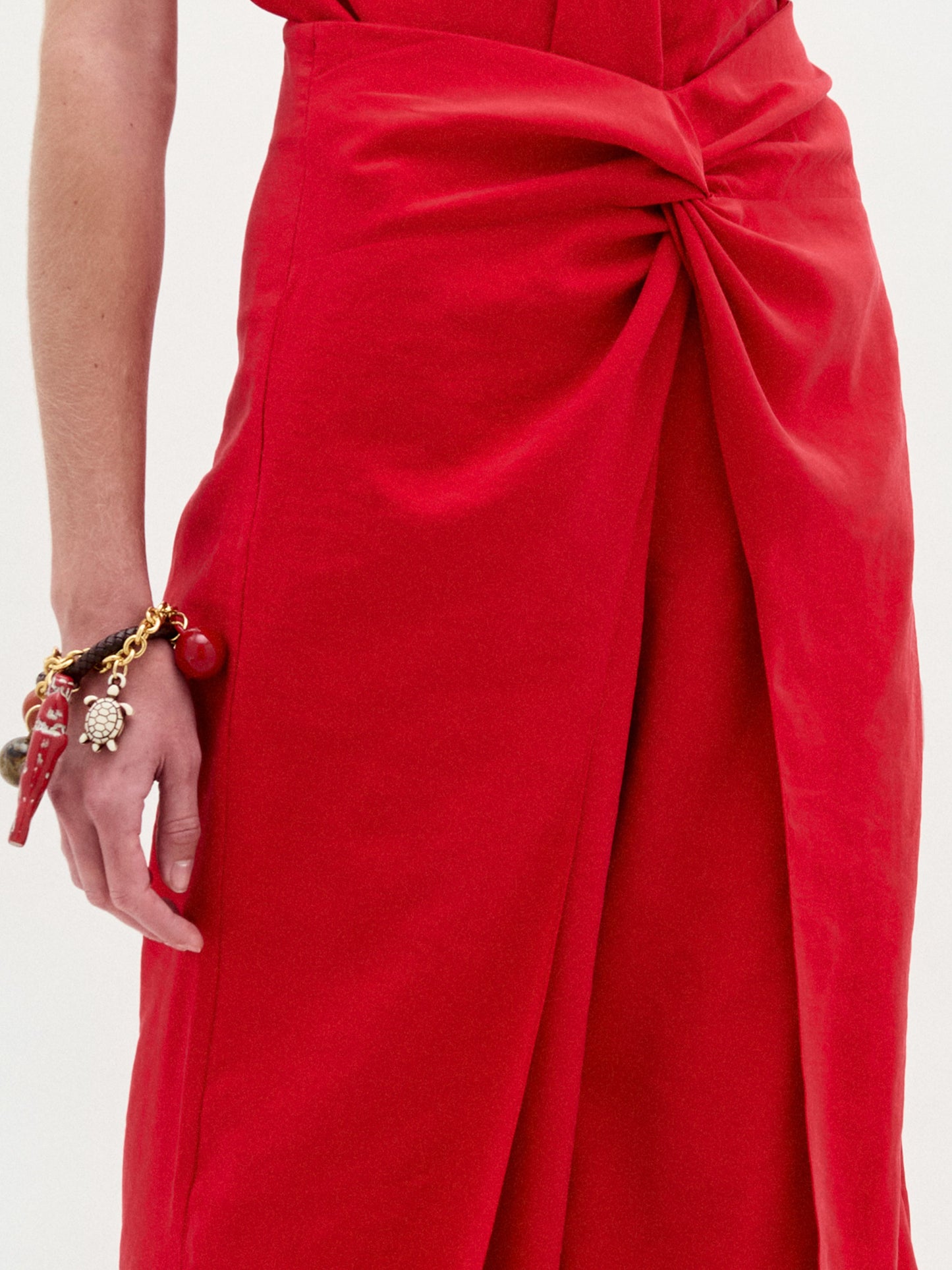Model showcases the Canturipe Pant, featuring a high-waisted, wide leg silhouette in bold red, styled with a sleeveless halter-neck top against a plain white background.