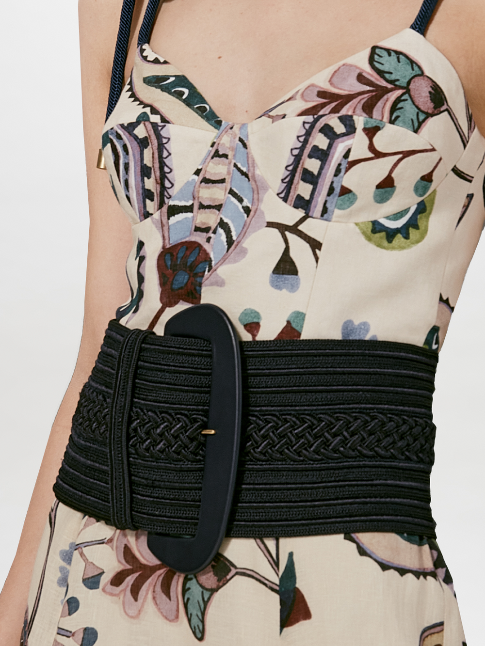 The Chenoa Belt is a wide black rayon accessory featuring an oversized oval buckle and decorative braided details, shown on a plain white background.