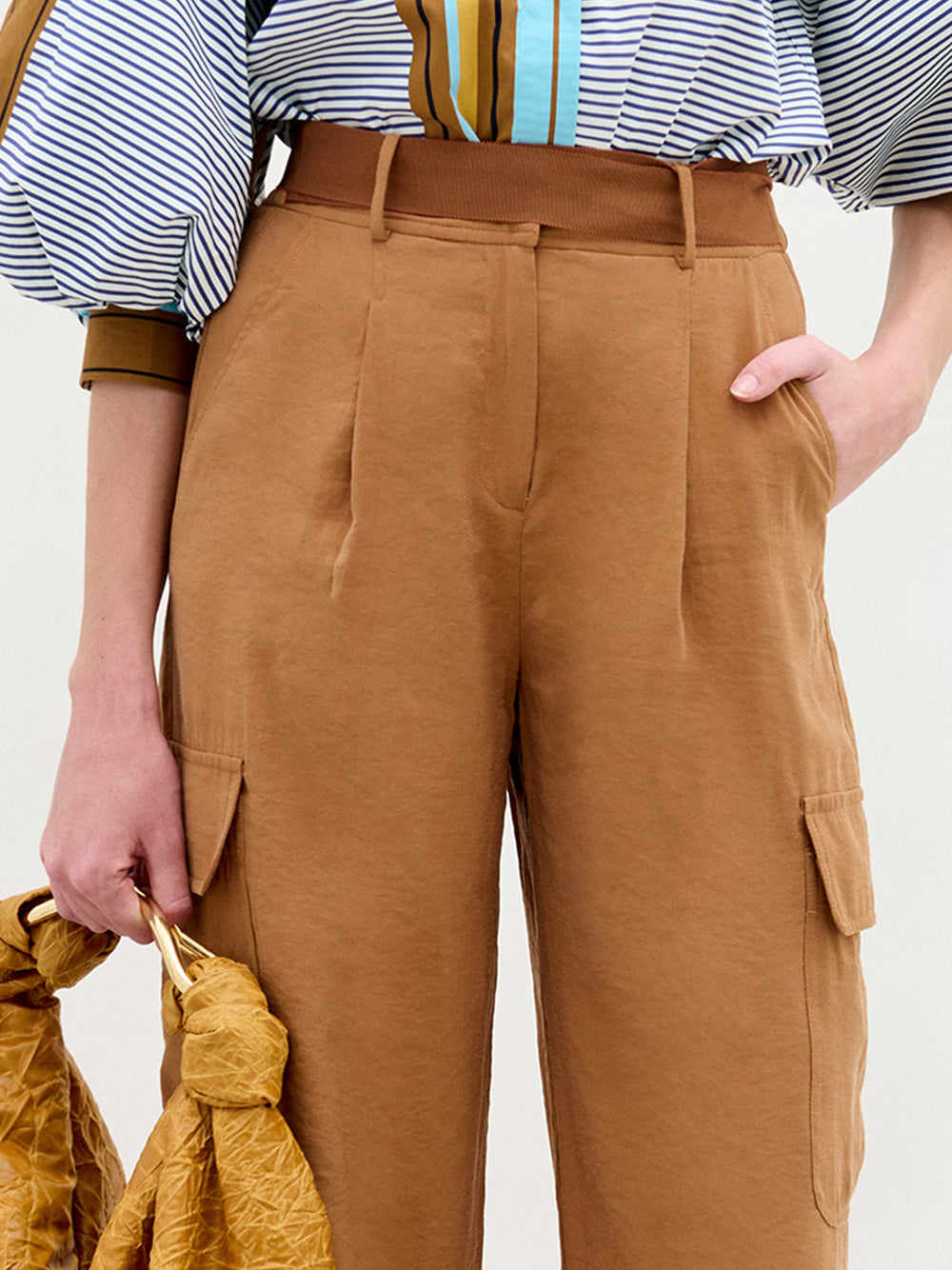 A person wearing the Darnell pant in color camel with the Sofia Bag Maxi in color Mustard on a white background.