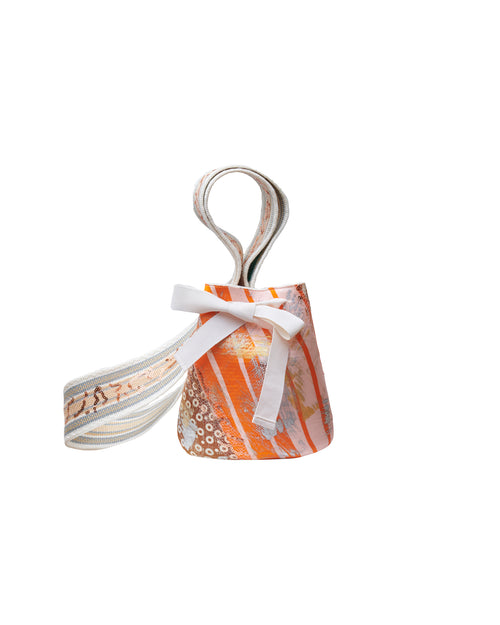 A Mochila Laaput Small Beige handbag with orange and white tones, a bow, and striped handles, isolated on a white background.
