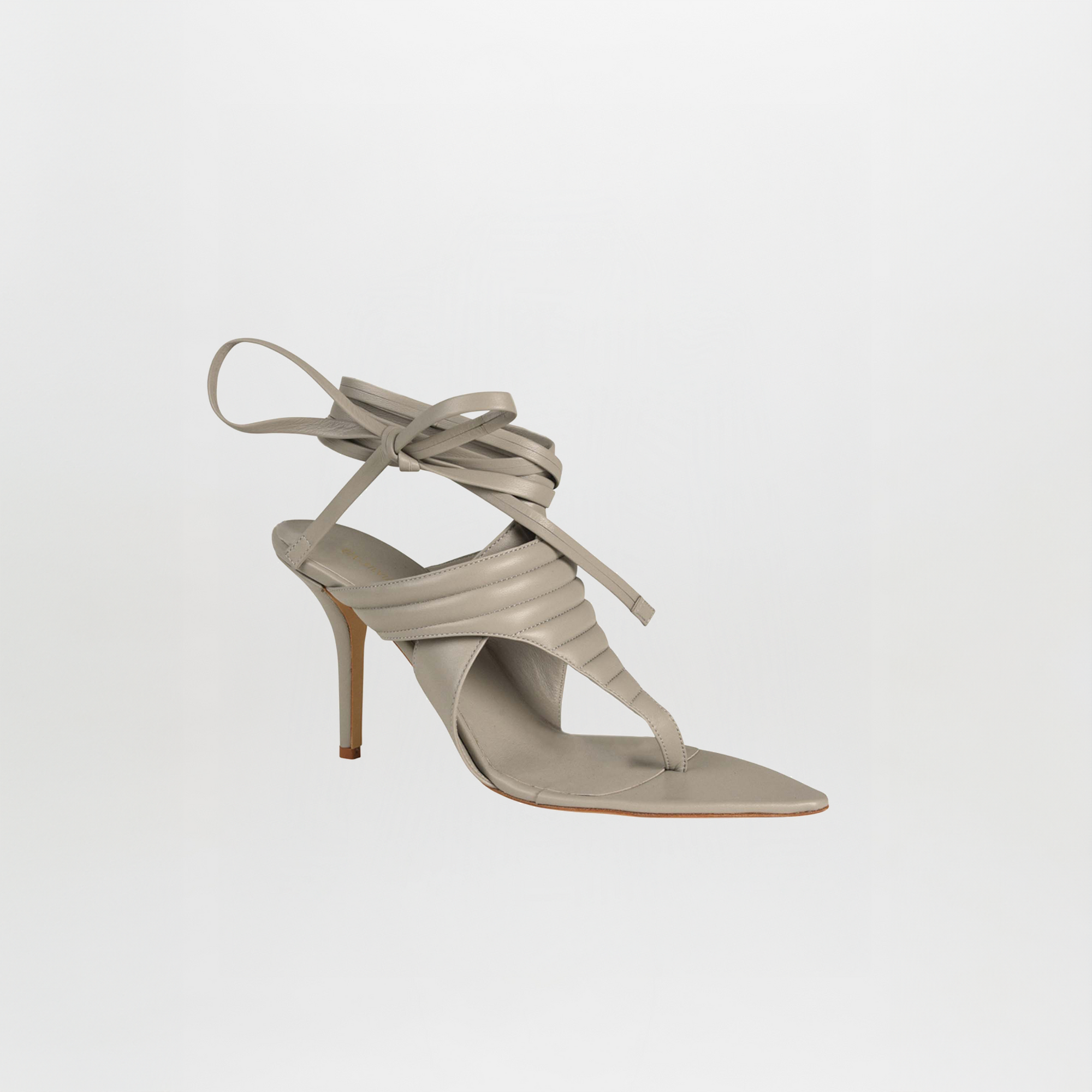 A grey Dalila heels sandal crafted from Italian calf leather, featuring a quilted toe-thong, square toe, padded upper, and long ankle wrap laces, displayed on a plain white background.