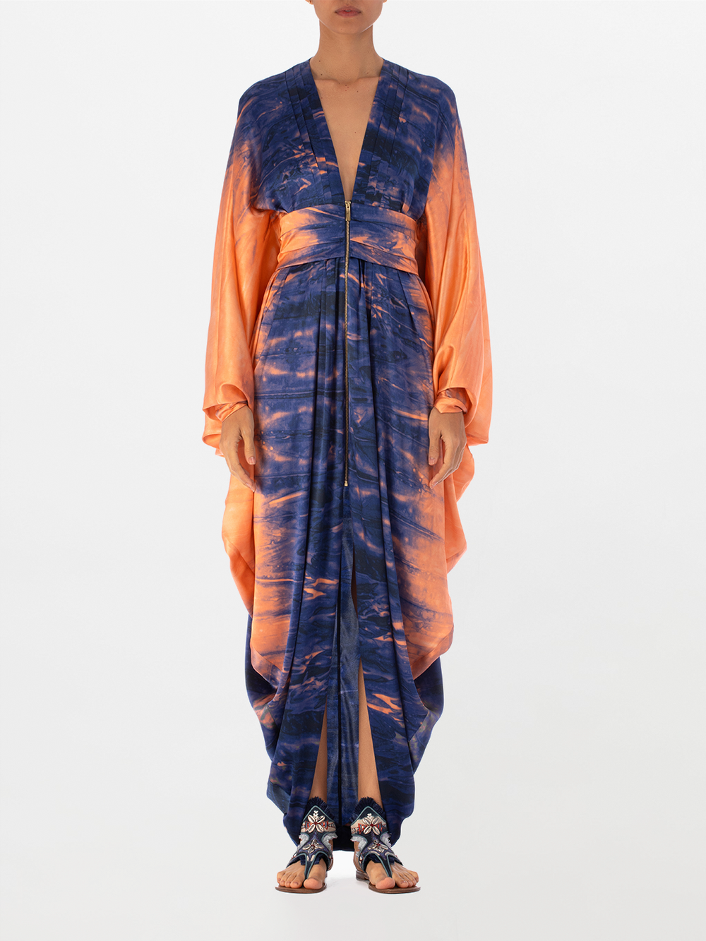 A long, flowing Danette Dress Mediterranean Coral Blue with blue and orange tie-dye patterns, displayed against a white background.