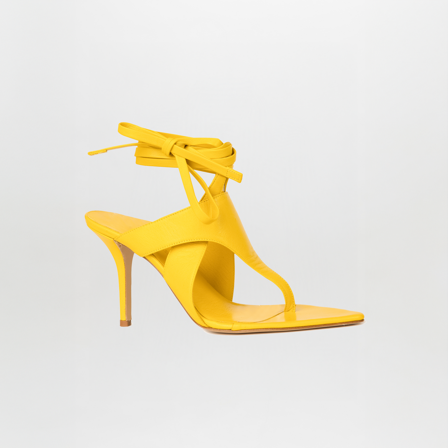 The Domenico Heels Limoncello by GIA Couture are yellow Italian leather sandals featuring a thong toe, ankle wrap straps, and a stiletto heel, showcased on a plain white background.