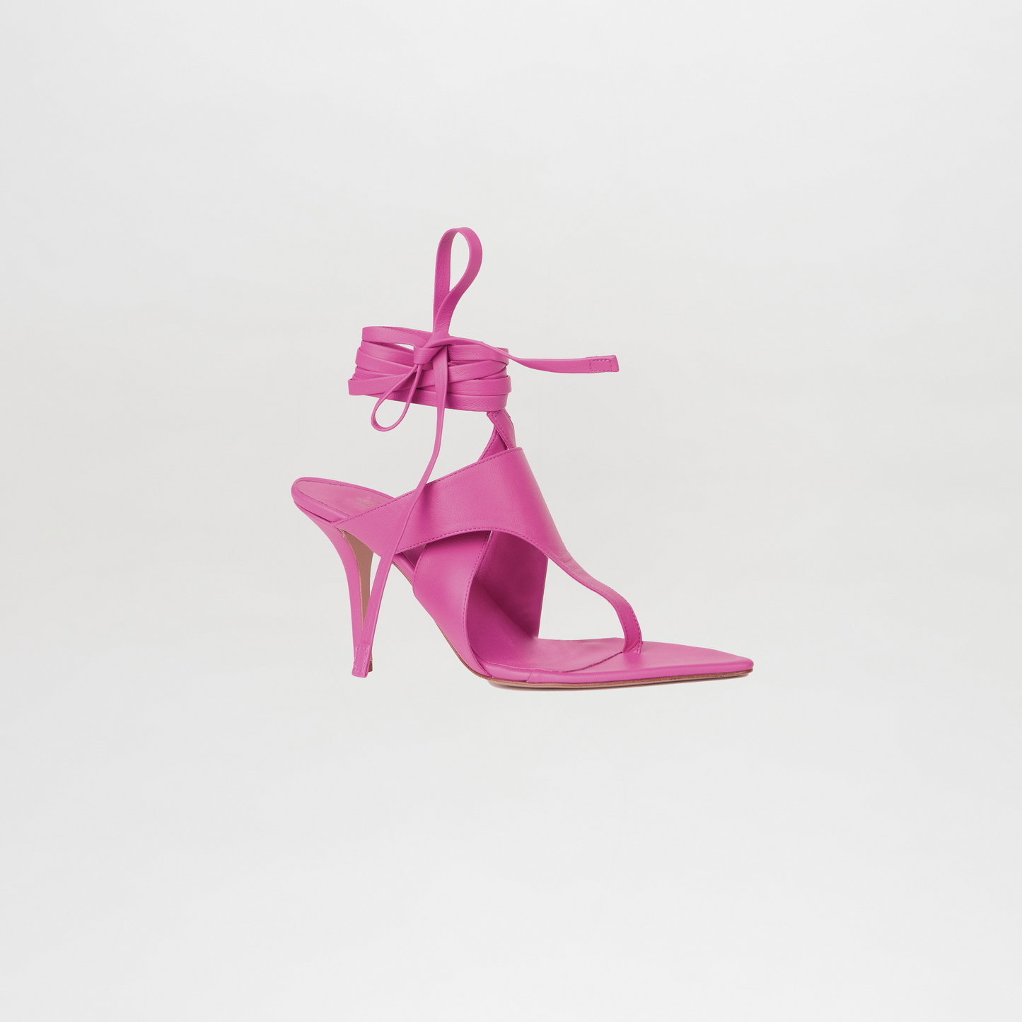 Pink high-heeled sandal with ankle strap on a light gray background