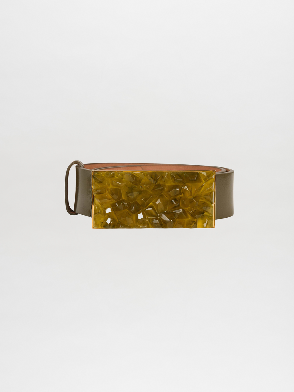 The Dora Belt Olive features an olive leather strap with a geometric yellow buckle, inspired by the Silvia Tcherassi Resort 2023 collection, blending elegance with contemporary flair against a neutral background.