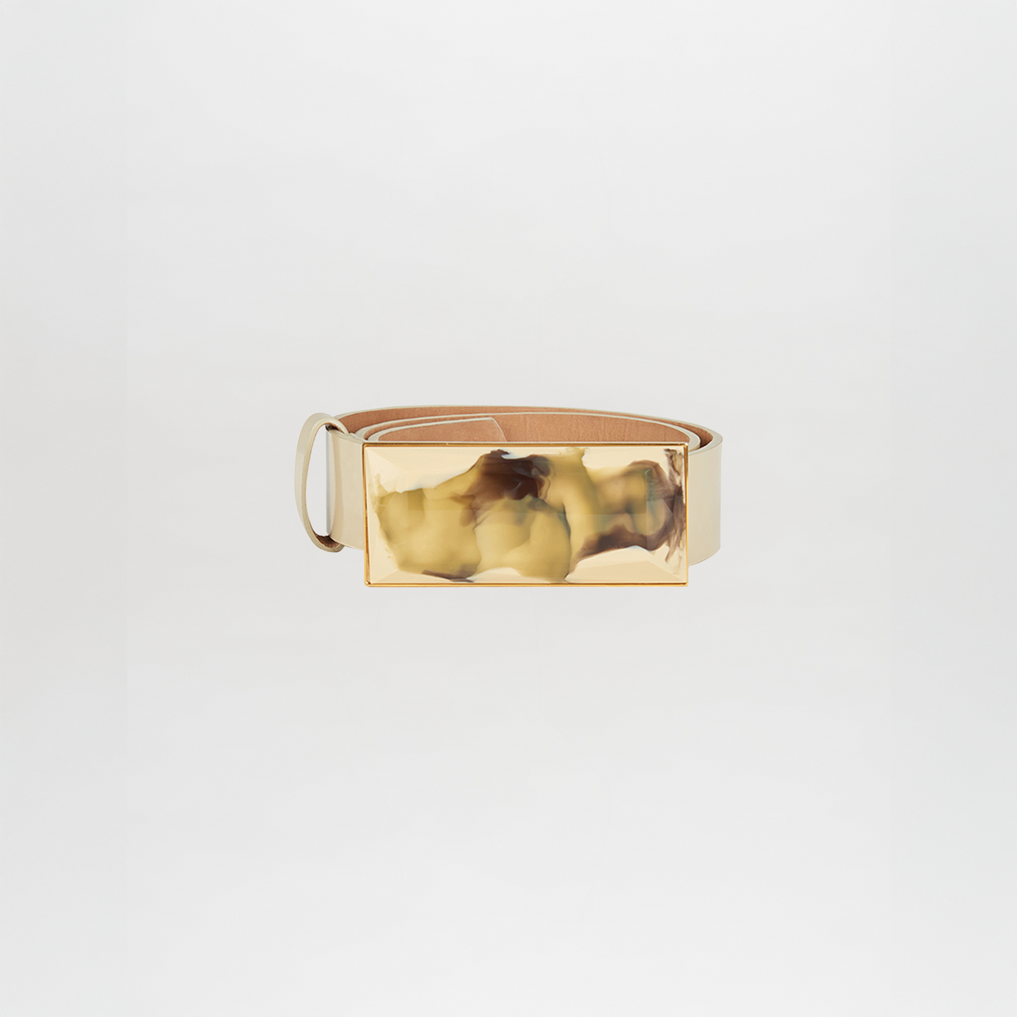 A pastel yellow leather Silvia Tcherassi Dora Belt featuring a large, rectangular, gold-toned marbled buckle is displayed against a plain white background—perfect as a statement accessory for any outfit.