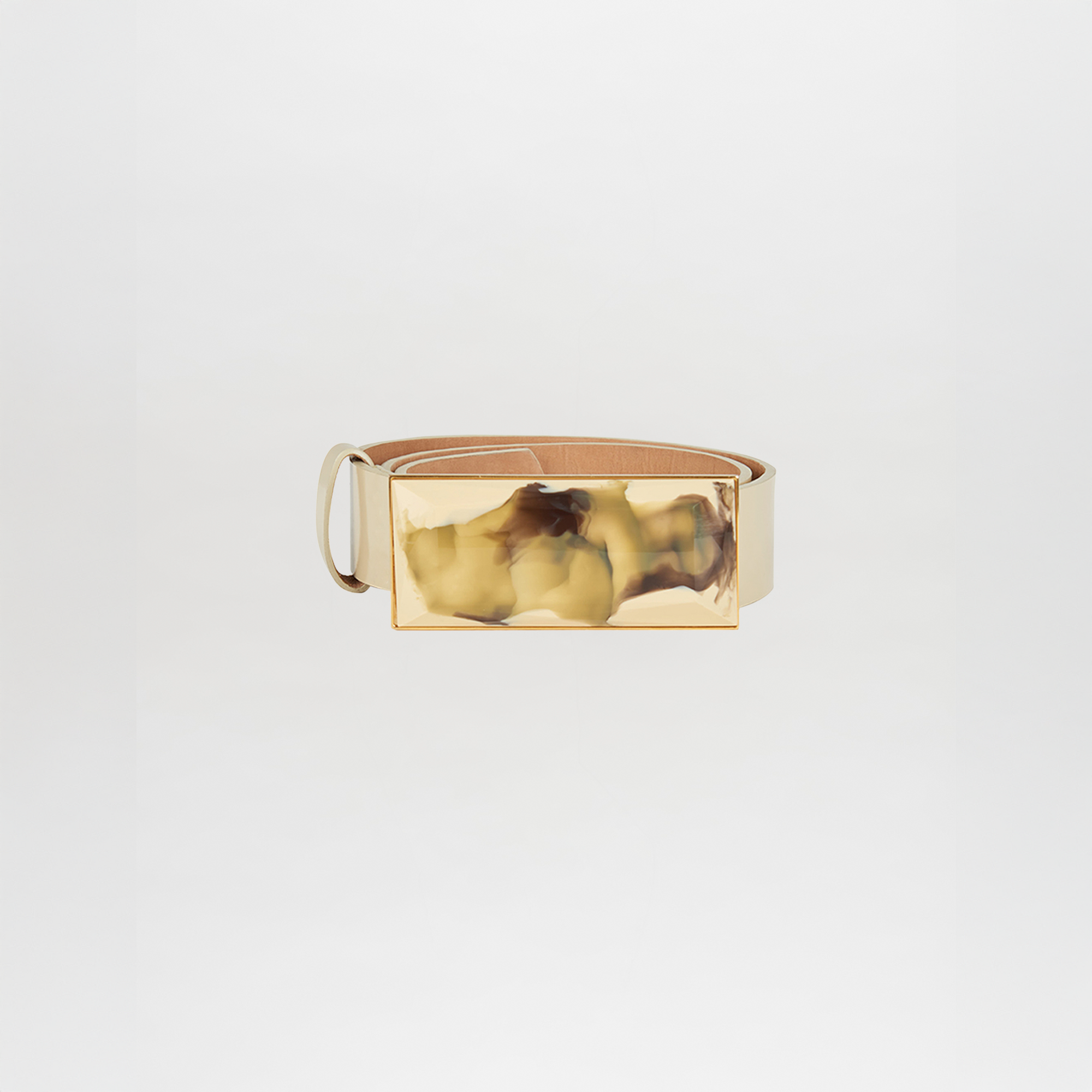 A pastel yellow leather Silvia Tcherassi Dora Belt featuring a large, rectangular, gold-toned marbled buckle is displayed against a plain white background—perfect as a statement accessory for any outfit.