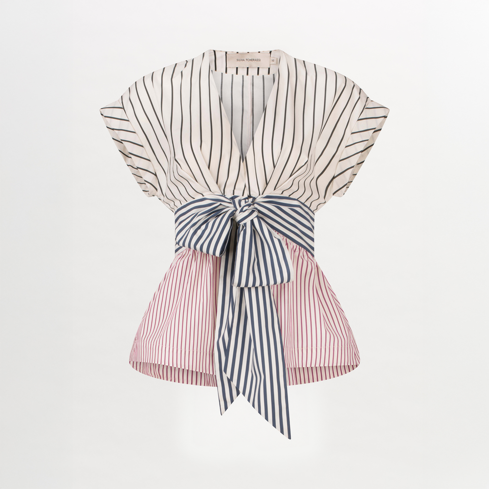 A white and blue striped Elia blouse with a bow, made of cotton fabric.