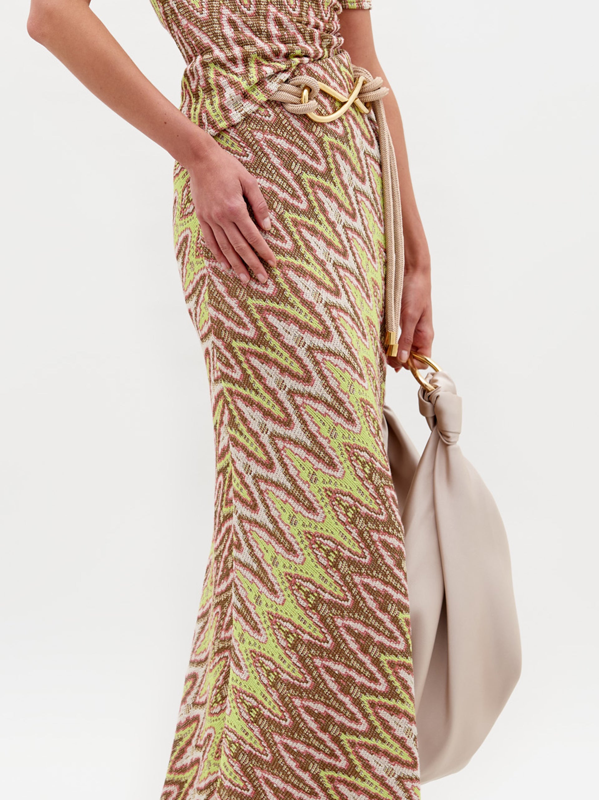 A person wearing the Famara Skirt with the Sofia Bag Maxi in color Beige on a white background.