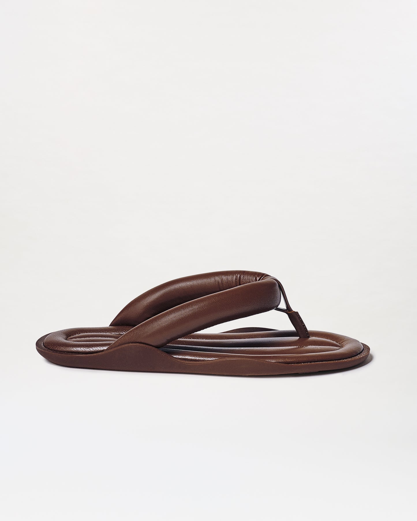 The Harper Sandals are brown padded flip-flops featuring thick, cushioned straps and a rounded sole, shown on a plain white background.