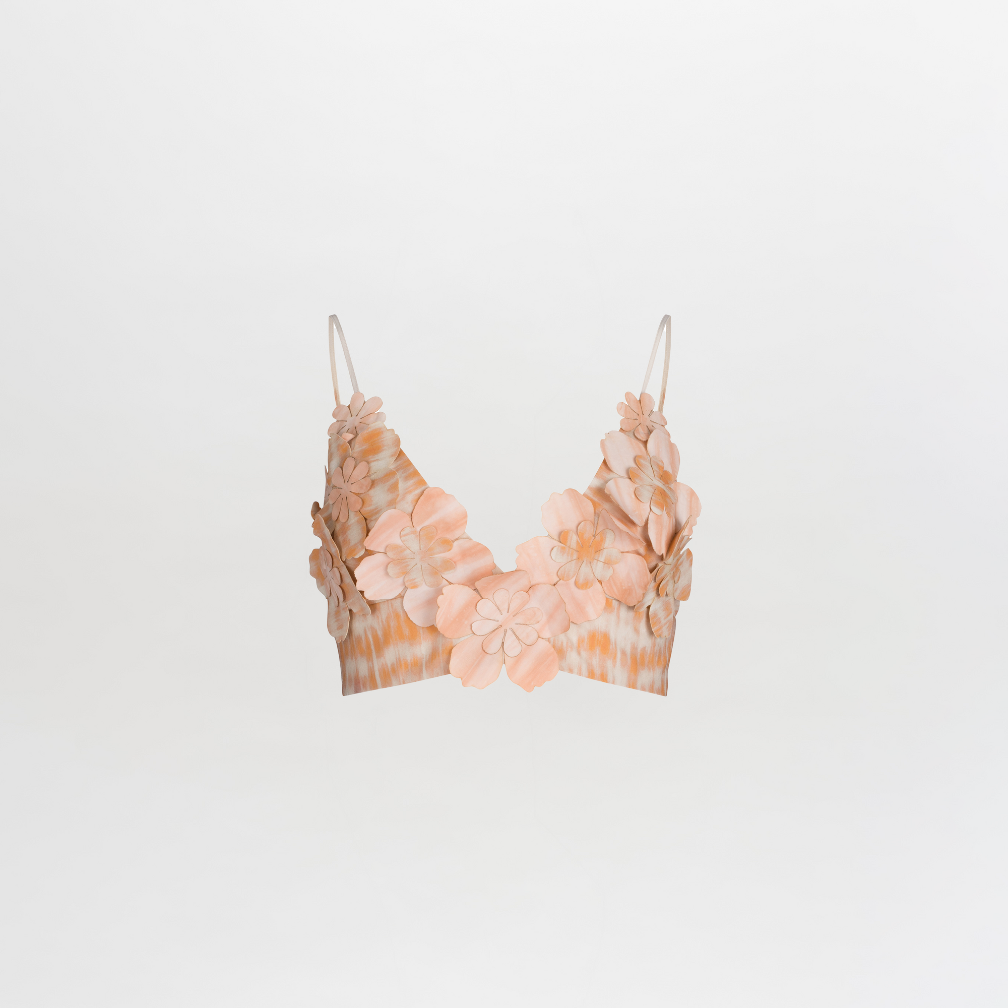 The Ibbie Top Mediterranean Coral Blue is a crop top bralette with spaghetti straps, showcasing exquisite floral detailing and 3D flower embellishments in soft shades of peach and beige on a plain white background.