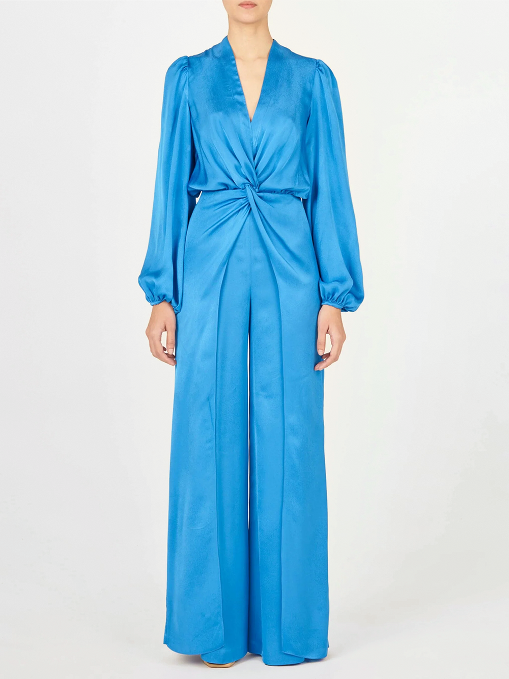 Woman standing with her back facing the camera, wearing the Arnetia Jumpsuit Blue with wide-leg pants.
