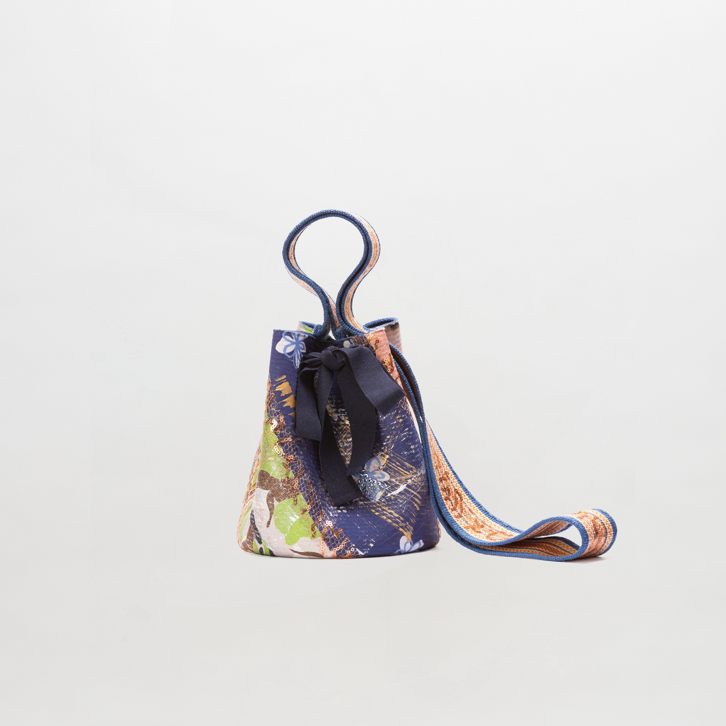 Multicolored bucket bag with a strap on a light gray background