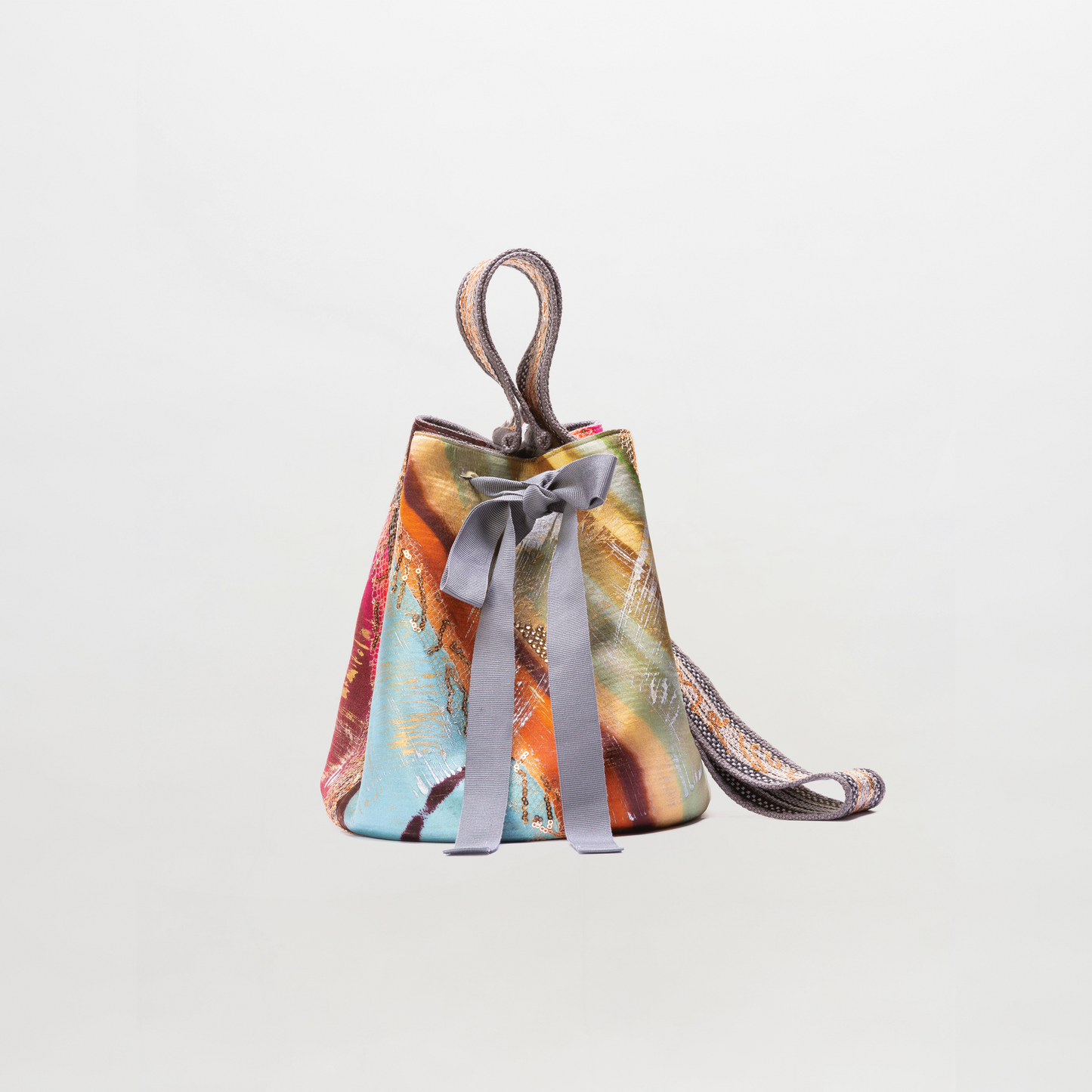 Colorful handbag with a ribbon on a light gray background