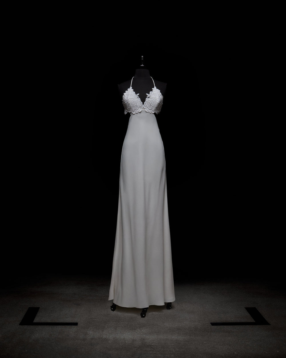 A woman in the Lua Dress holds a bouquet of flowers.