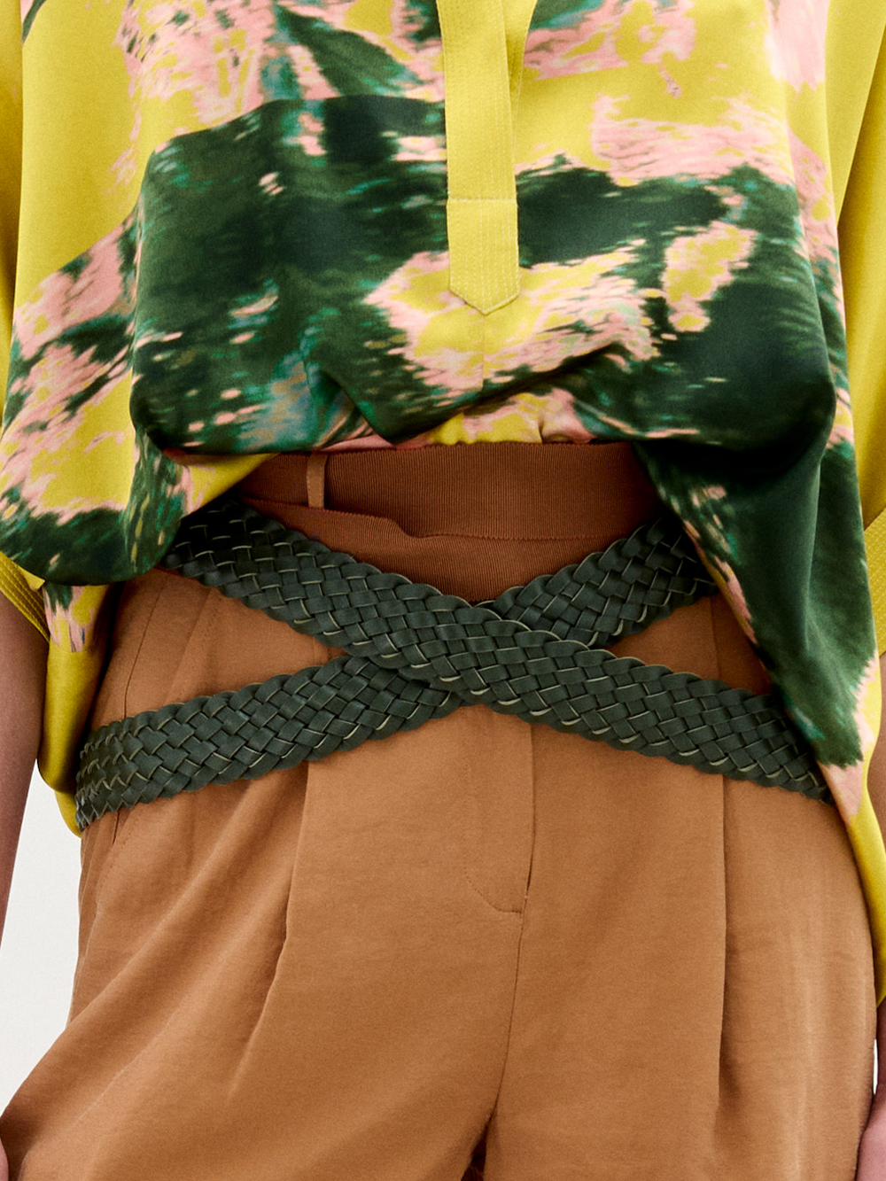 The Lauren Belt, crafted in Colombia, features a coiled design with dark green woven leather and is shown on a plain white background.