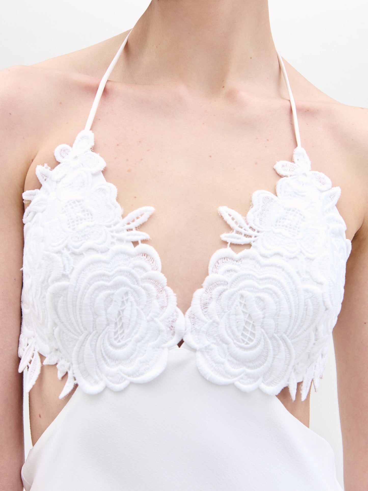 A woman in the Lua Dress holds a bouquet of flowers.