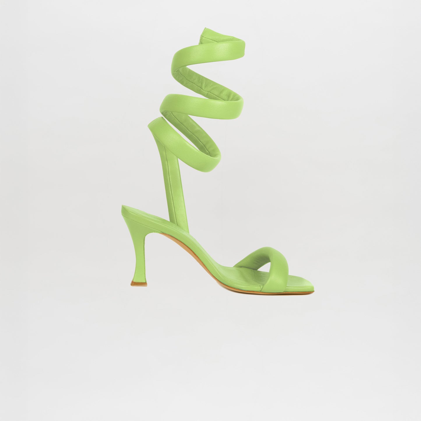 A single Mika Heels Green, crafted from Italian calf leather with a spiral ankle strap and open toe in a chic sorbet lime hue, is photographed against a plain white background.