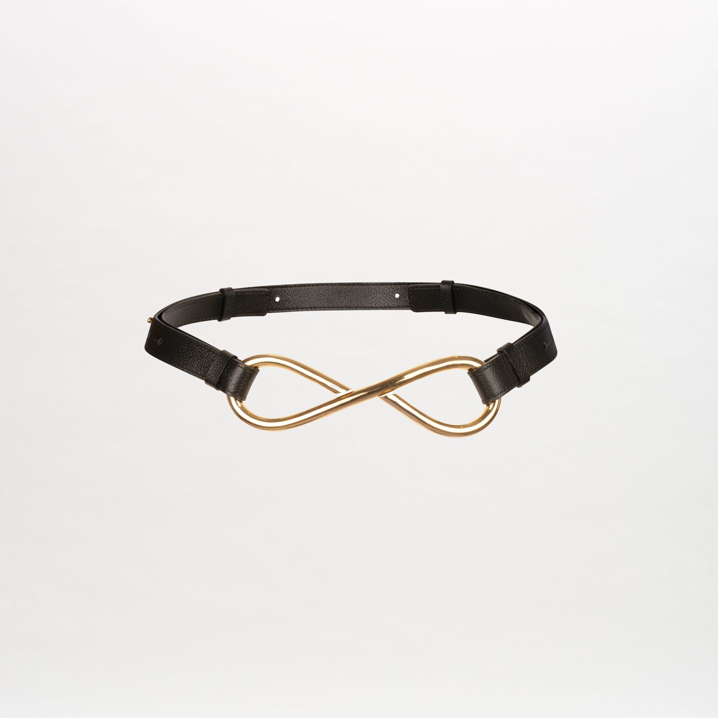 The Oihana Belt, a leather accessory with an adjustable strap and a gold infinity-shaped buckle, is showcased on a plain white background.