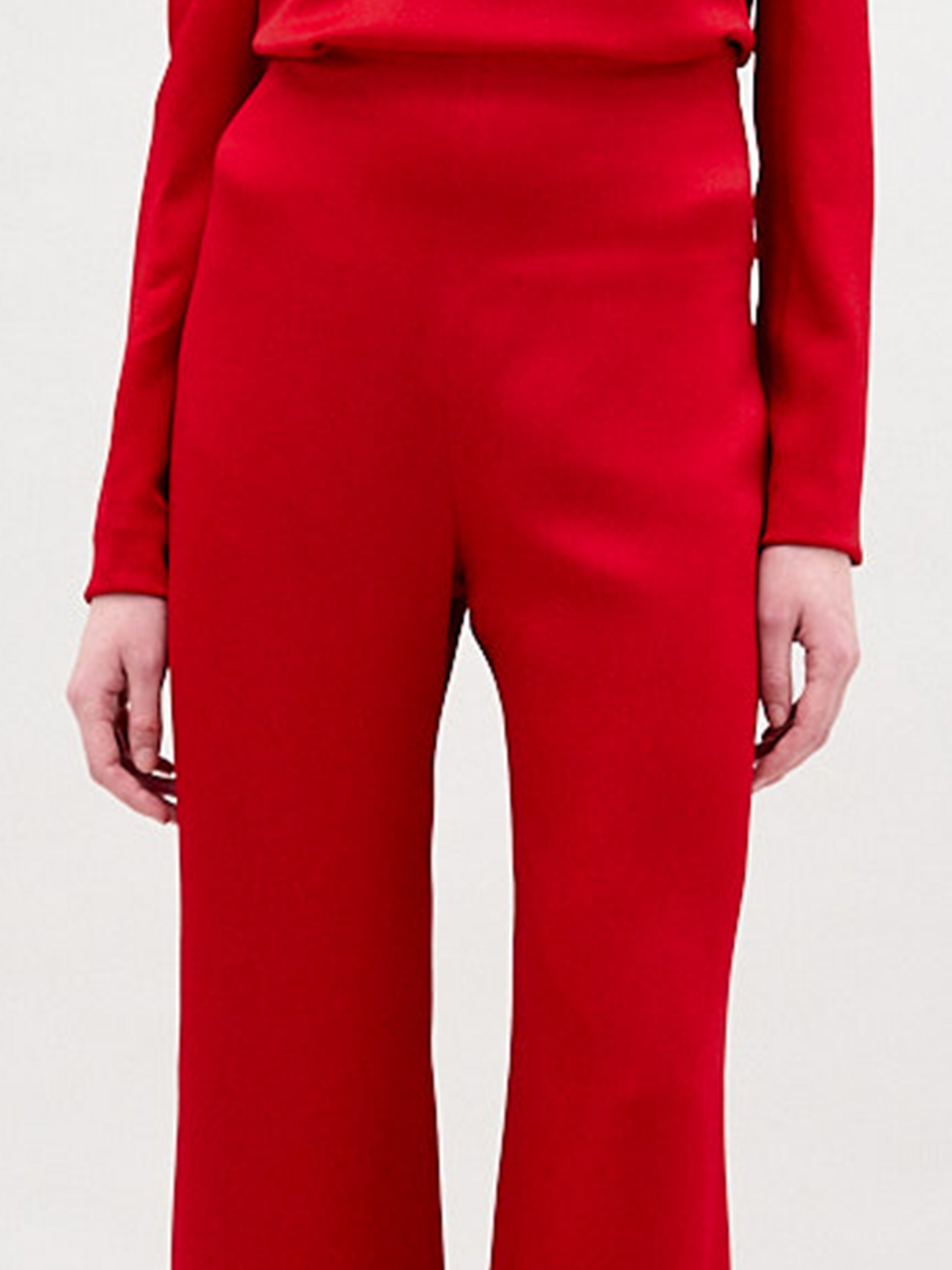 A woman wearing the Palermo pant in color rouge on a white background