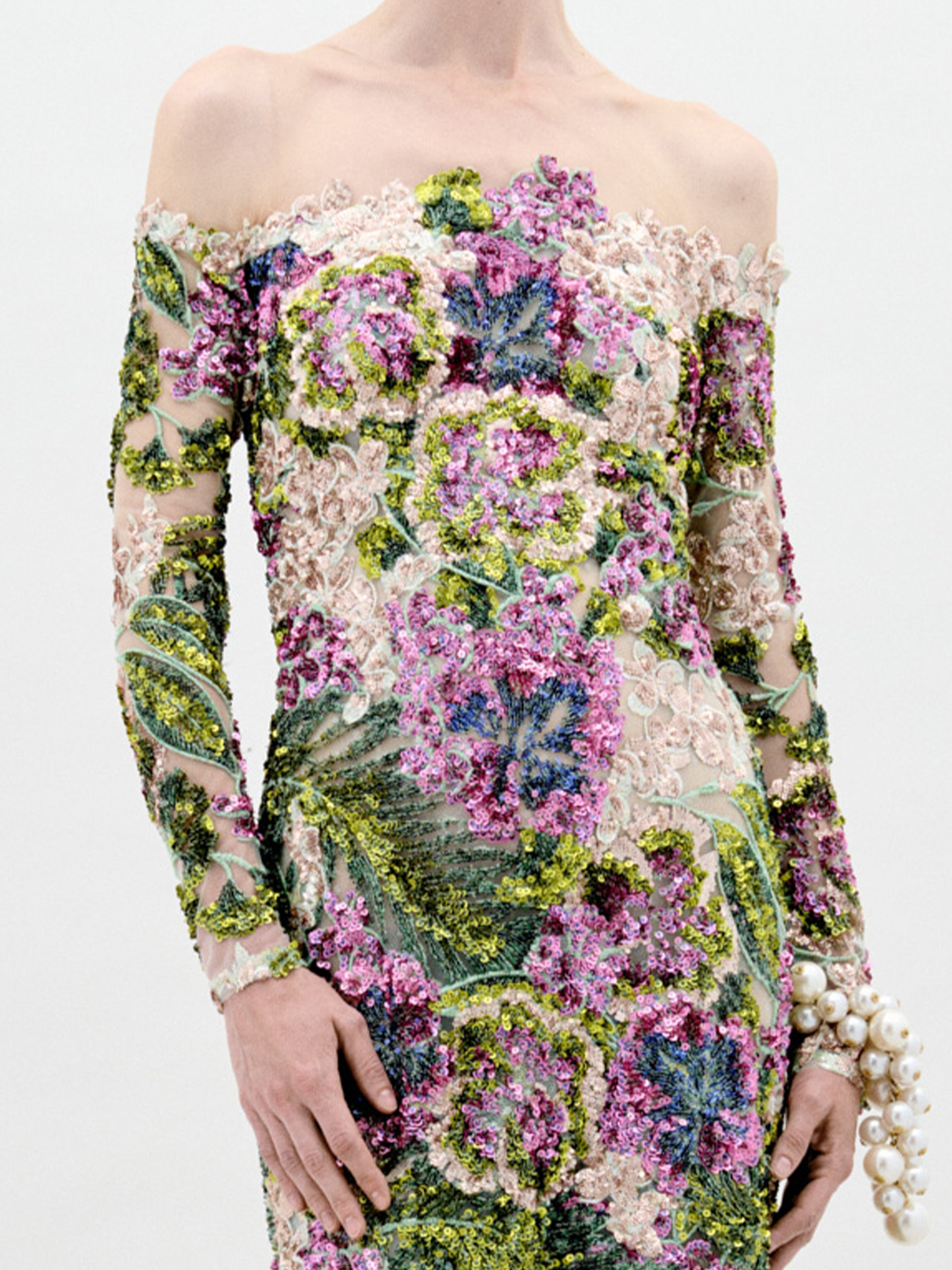 A person stands against a plain background wearing the Rafaella Dress