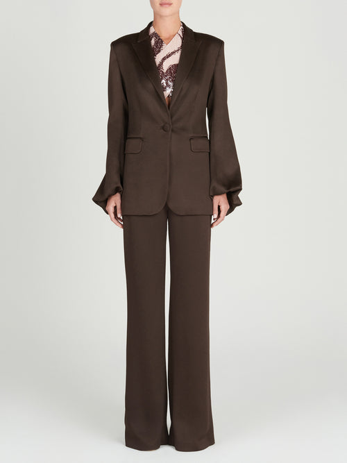 A Coco Blazer Brown in hammered satin fabric with ruffled sleeves.