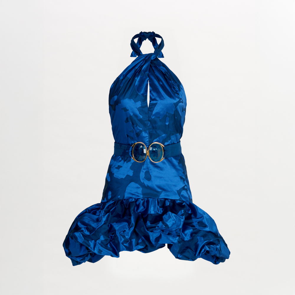 The Rea Dress Navy with a ruffled skirt and a gold belt.