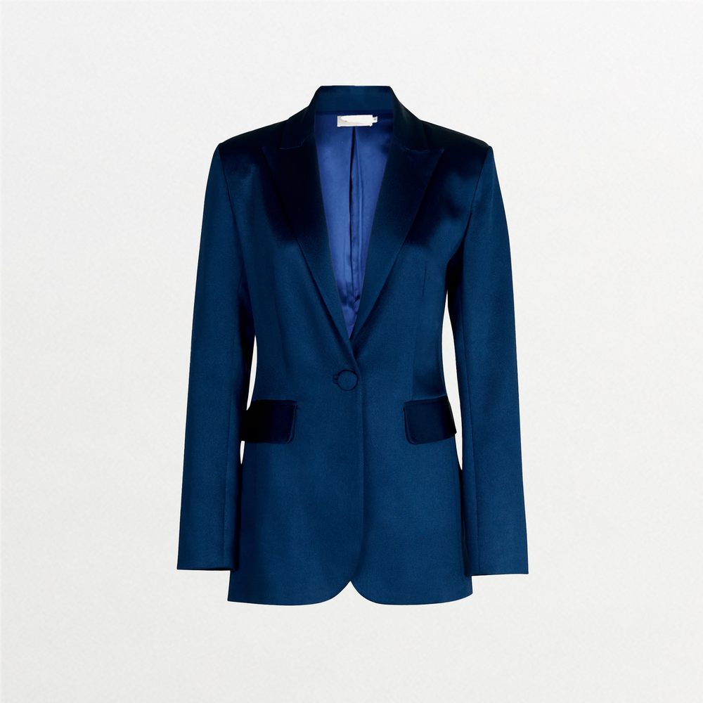 The Rebeca Jacket, in dark blue hammered silk, features a single button closure, notched lapels, and two front flap pockets. It is shown against a plain white background.