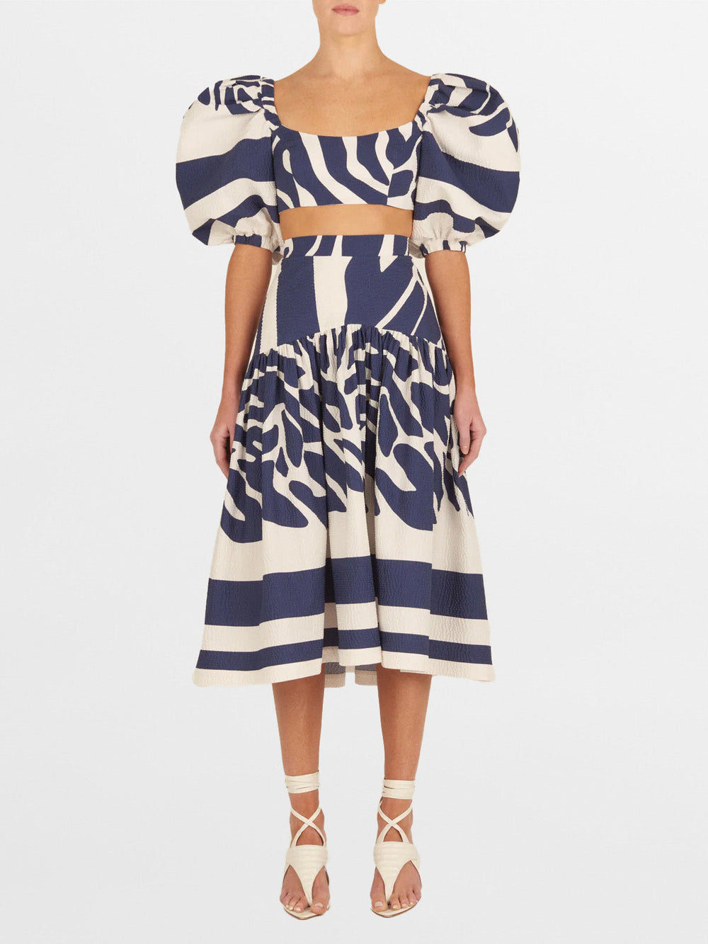 The Elena Top Navy White Mosaic features a striking blue and white zebra-print design on mosaic printed fabric, complete with puffy short sleeves.