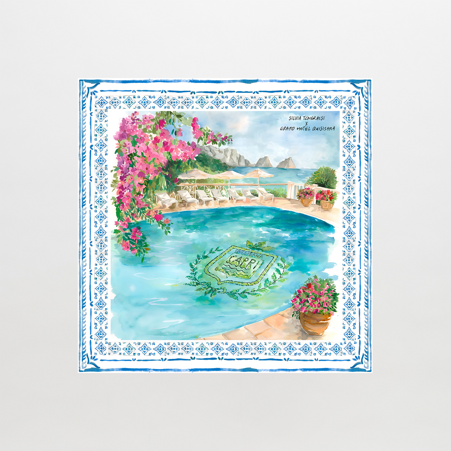 The Capri Scarf features a colorful illustration of a Mediterranean pool surrounded by flowers, greenery, lounge chairs, umbrellas, and rocky sea cliffs, all bordered with a blue decorative pattern.