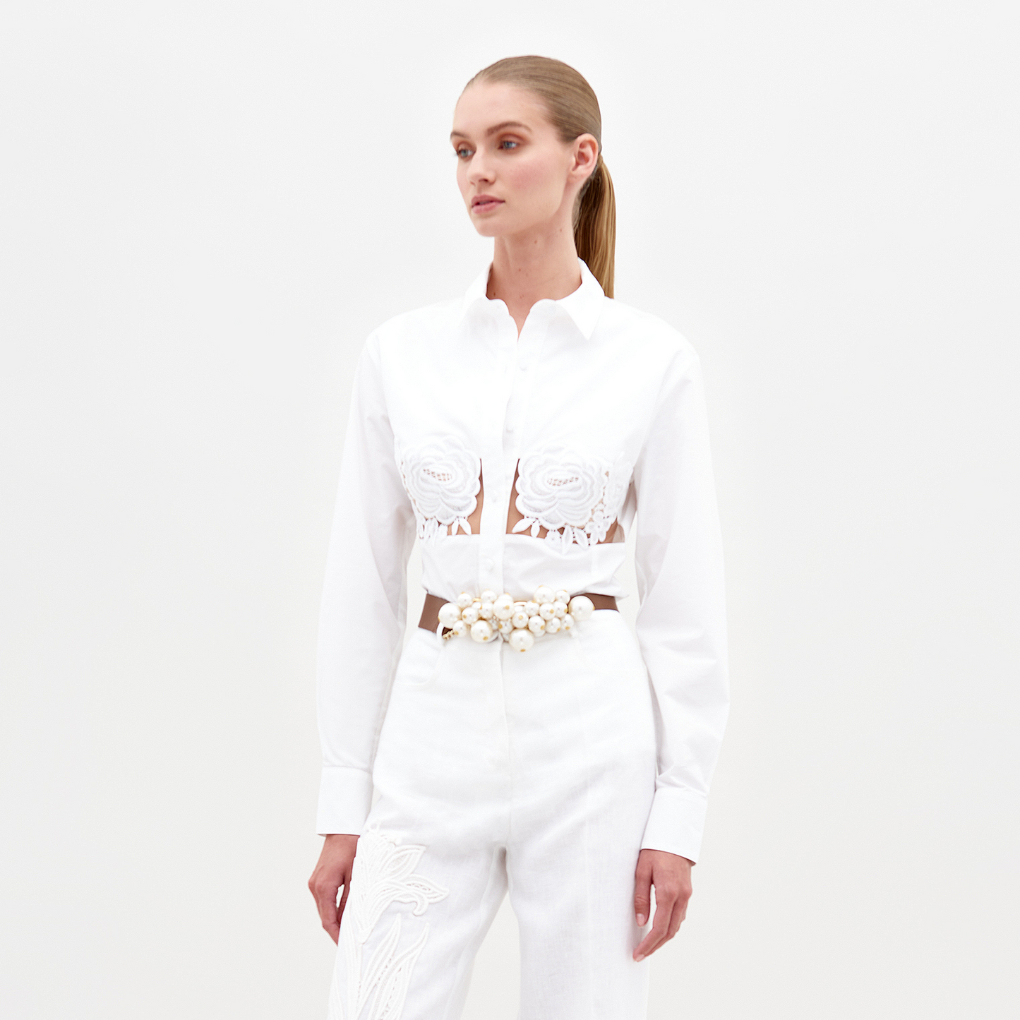 A person stands against a plain background wearing the Sigrid blouse in color White