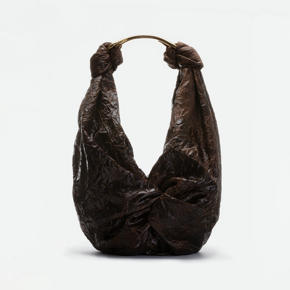 The Sofia Bag (Maxi) is a large, dark brown crinkled bag featuring a knot design and a rounded gold-toned handle, displayed against a plain light background.
