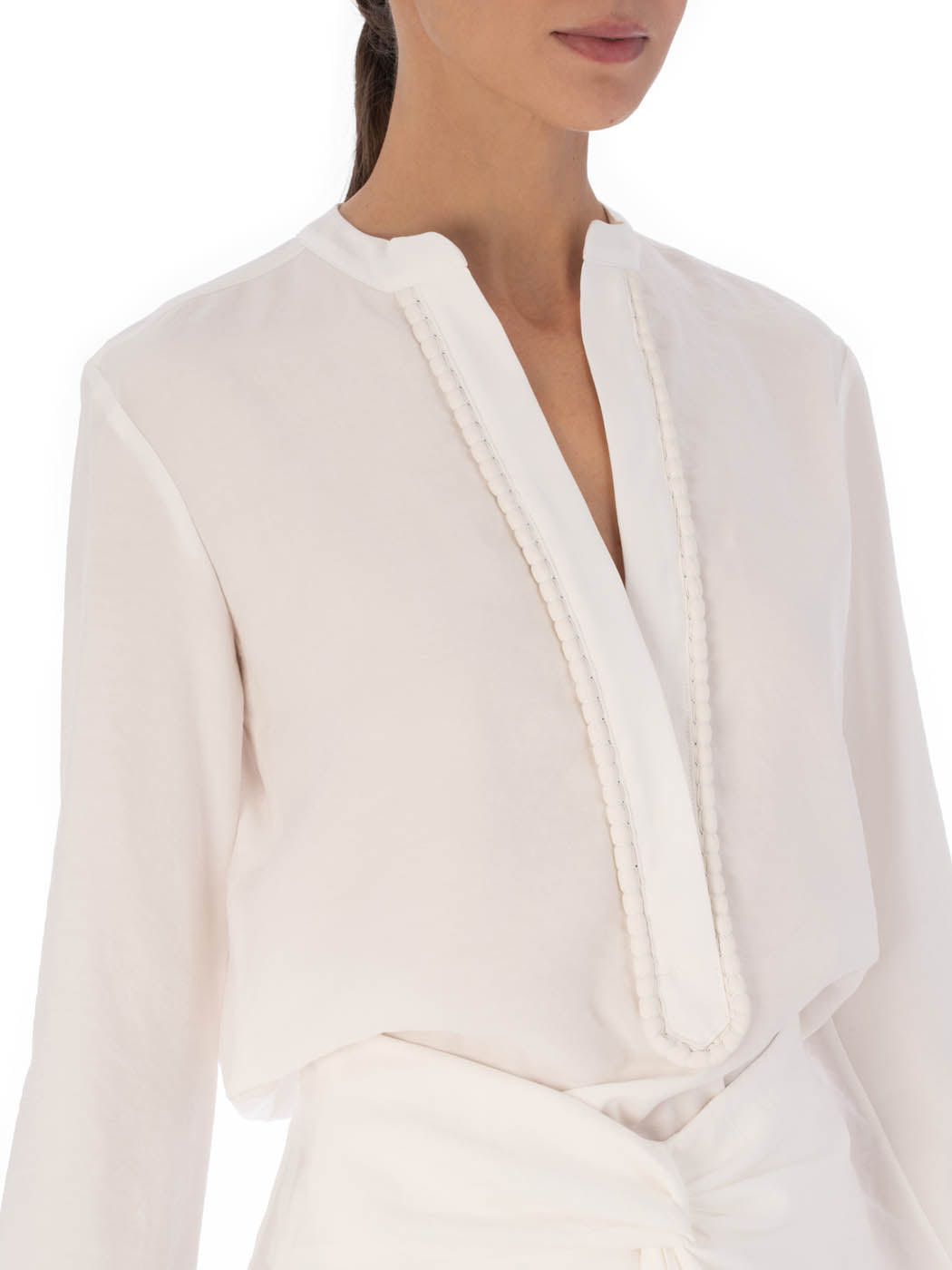 Shera Blouse White with a v-neckline and long sleeves, displayed on a plain background.