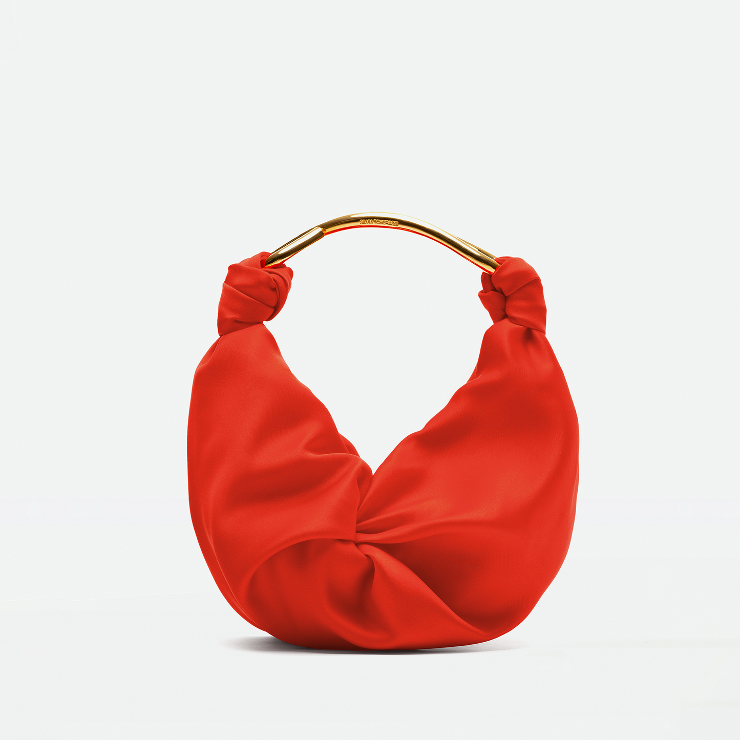 The Sofia Bag Small is a red, crescent-shaped handbag crafted from luxurious doppio raso with a gold handle, showcased against a plain background.