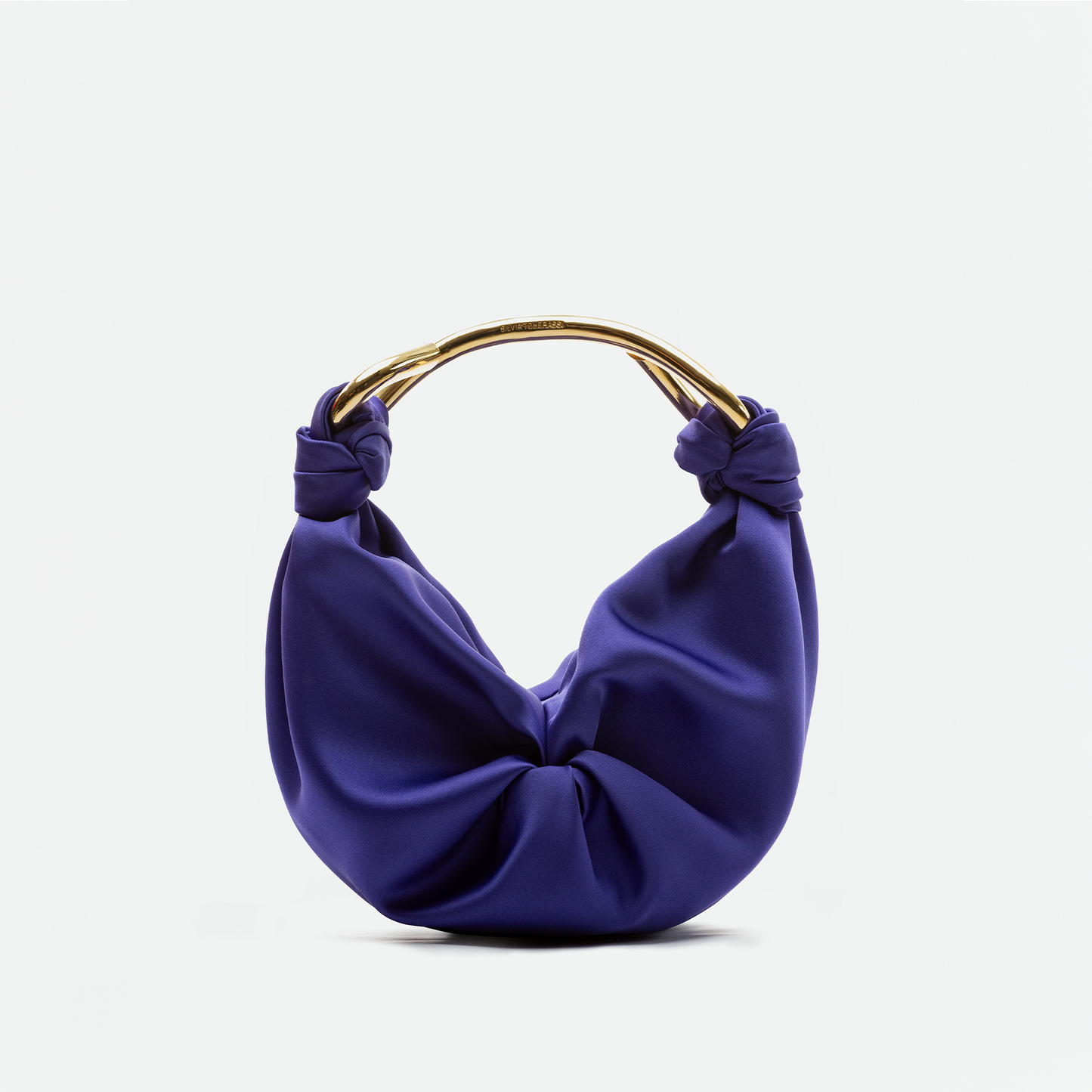 The Sofia Bag Small is a purple, knotted handbag with a soft, draped Italian fabric body and a curved gold-toned handle, shown on a plain white background.
