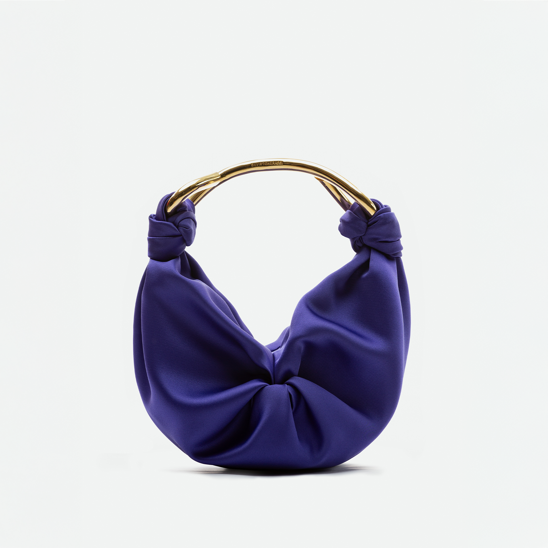 The Sofia Bag Small is a purple, knotted handbag with a soft, draped Italian fabric body and a curved gold-toned handle, shown on a plain white background.