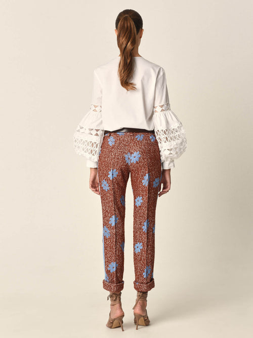 A white Aline Blouse with embroidered sleeves.