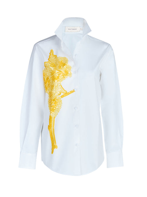 A Rimini Blouse White with a gold embroidered design.