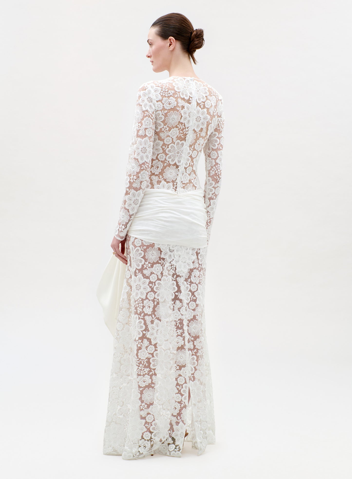 Woman wearing a long-sleeve lace dress on a white background