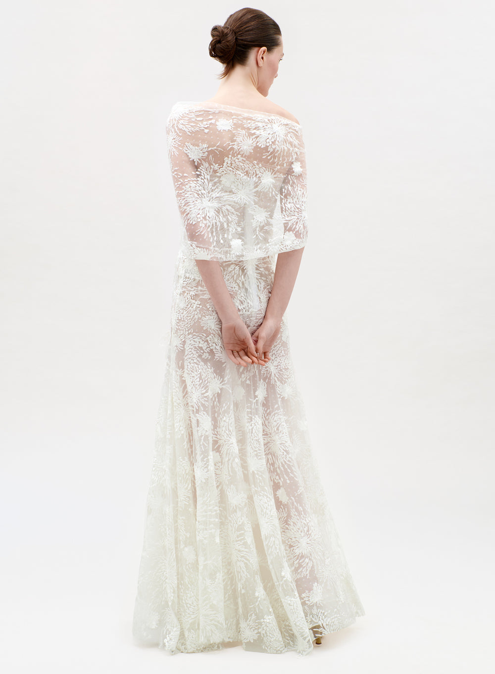 Woman wearing a white lace dress on a white background
